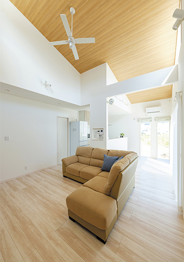大らかな勾配天井のLDKは明るく開放的で、すっきり白で統一された中で天井の木目と優しい床の色使いで木の温もりを感じるナチュラルな空間に。色数を抑えインテリアは統一感を出した。