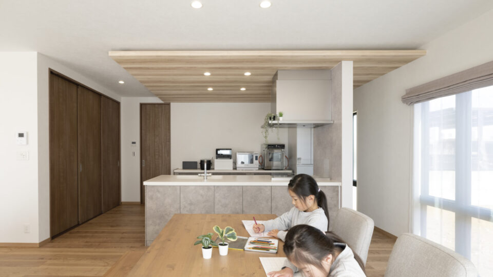 下がり天井の木目が印象的なおしゃれなキッチンは、家族みんなで並んで作業できるゆとりの広さ。

回遊動線も確保され、家事のしやすさにも配慮しています。